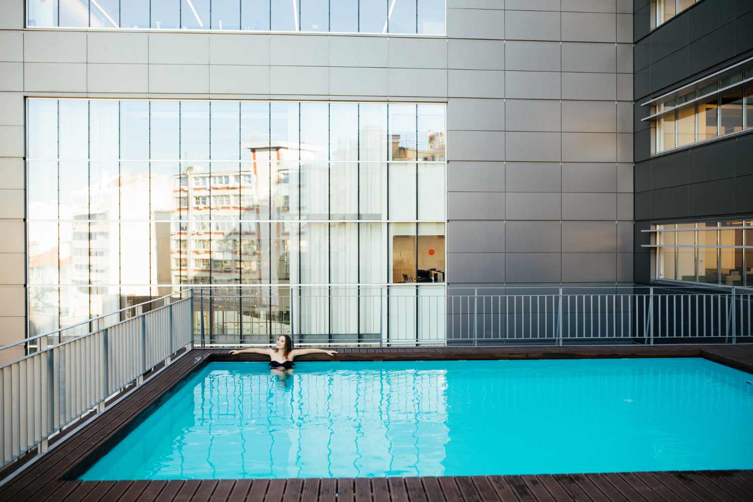 Modern aluminum pool fence surrounding a swimming pool, showcasing sustainable, corrosion-resistant design with sleek, contemporary aesthetics.